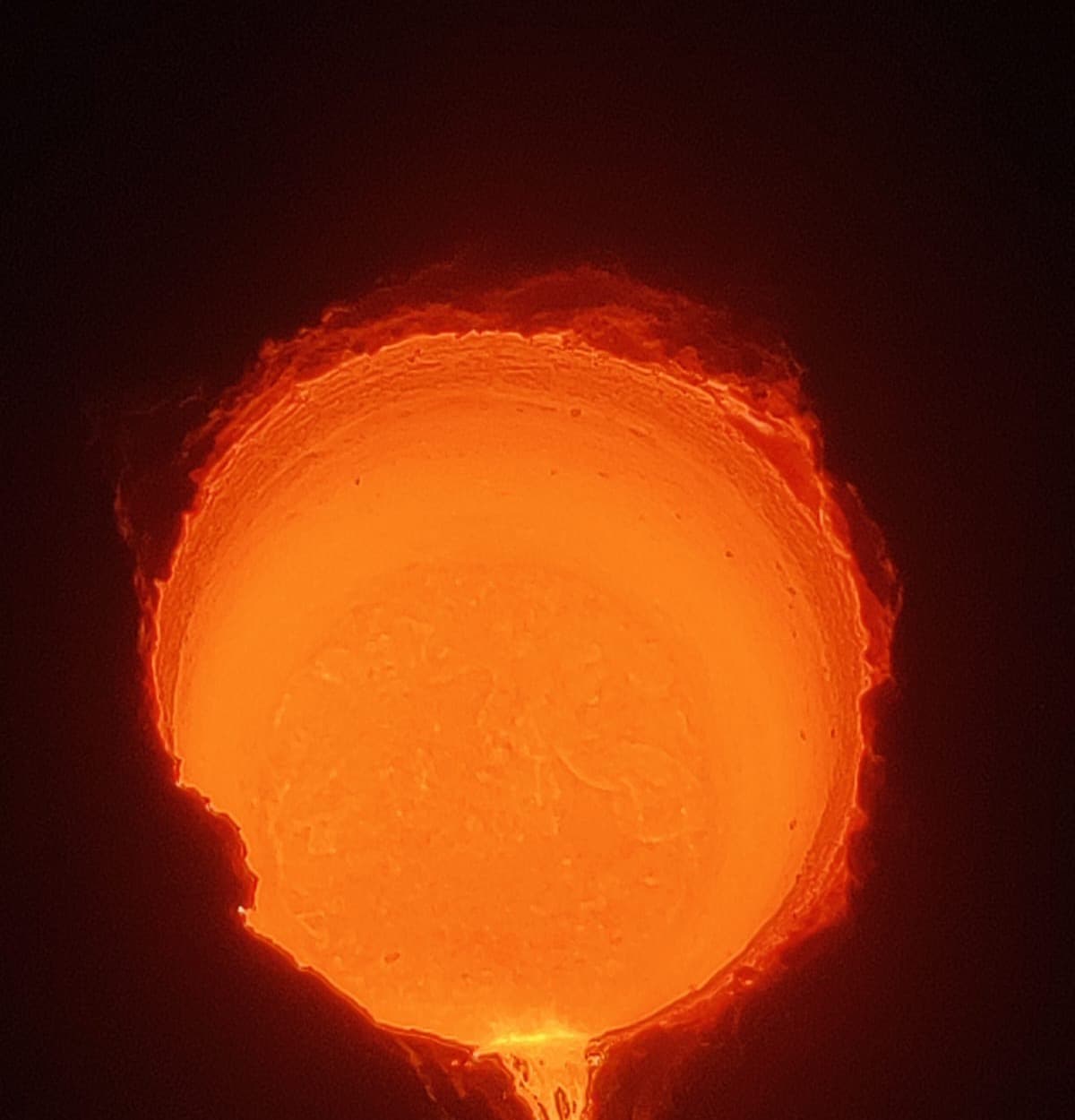 Molten metal glowing inside a coreless induction furnace lined with Lukorma neutral ramming mass