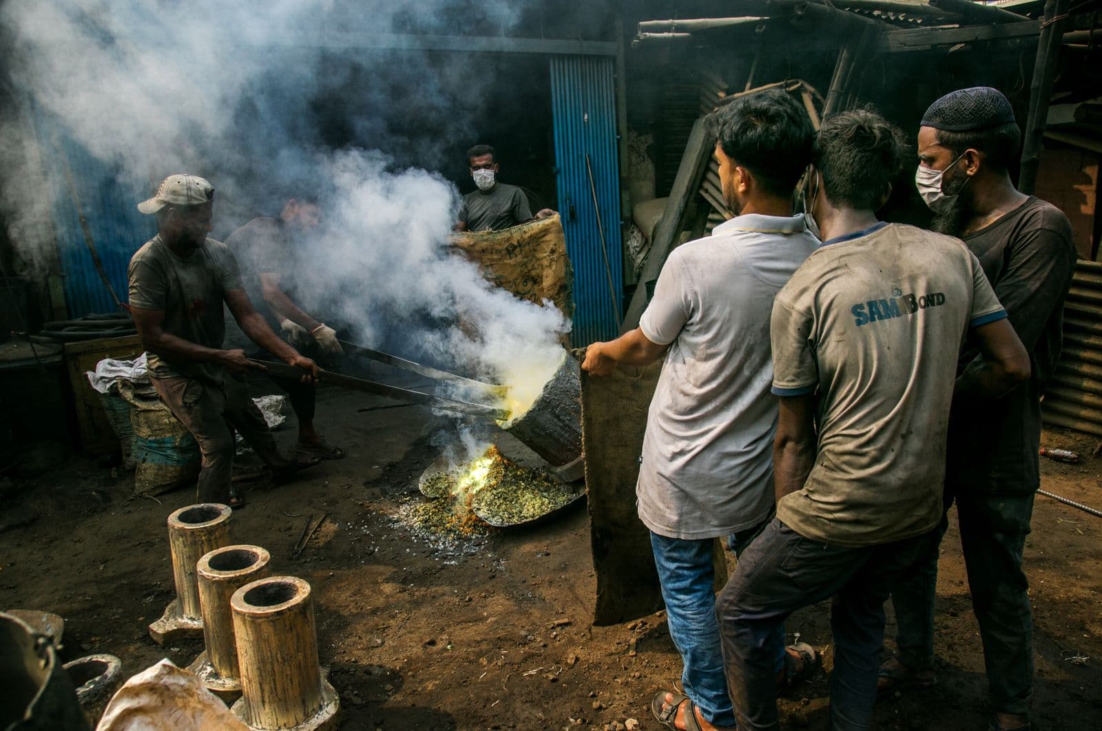 Workers at an industrial metal-casting foundry